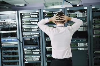 Uomo che guarda un data center con le mani tra i capelli perché non ha un piano di disaster recovery